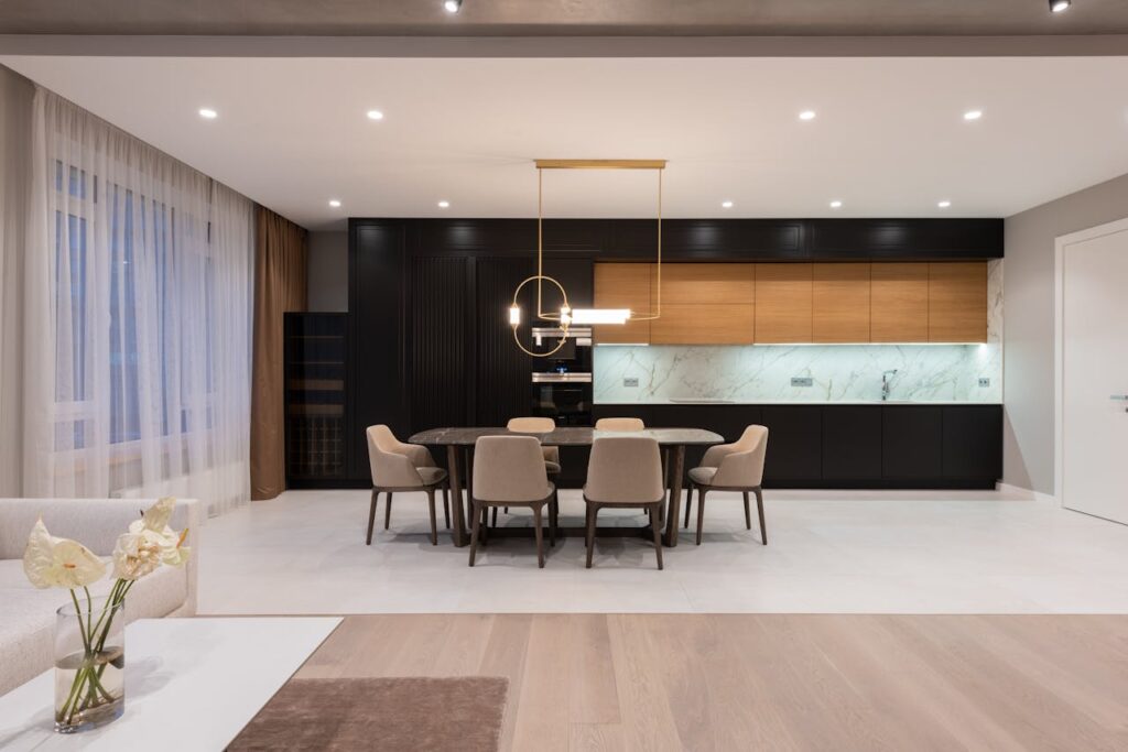 pexels-photo-6758779 Spacious modern kitchen with elegant decor, featuring a dining area and contemporary lighting.